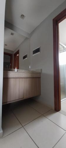 a reception desk in a room with a mirror at Flat Quartier - Aldeia das Águas in Barra do Piraí
