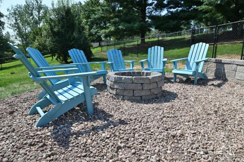 three blue chairs sitting next to a fire pit at Farmhouse in Hershey in Hershey