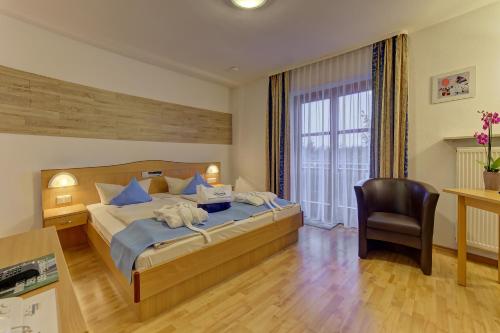 a bedroom with a bed and a desk and a chair at Landhotel Tannenhof in Spiegelau