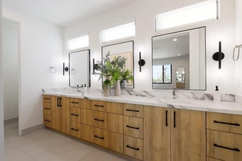 a bathroom with two sinks and two mirrors at Sunrift-Private Pool & Spa-Walk to Old Town in Scottsdale