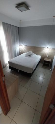 a bedroom with a bed in a room at Flat Quartier - Aldeia das Águas in Barra do Piraí