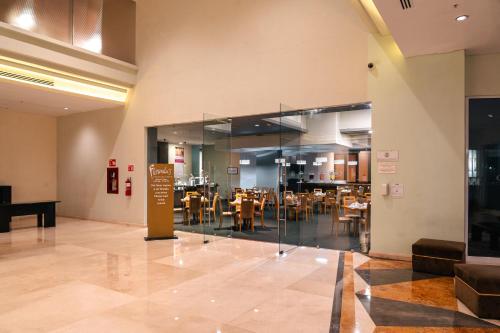 a restaurant with tables and chairs inside of a building at Crowne Plaza Monterrey Aeropuerto by IHG in Monterrey