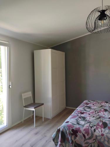 a bedroom with a bed and a chair and a cabinet at Petit Brunò in Monfalcone