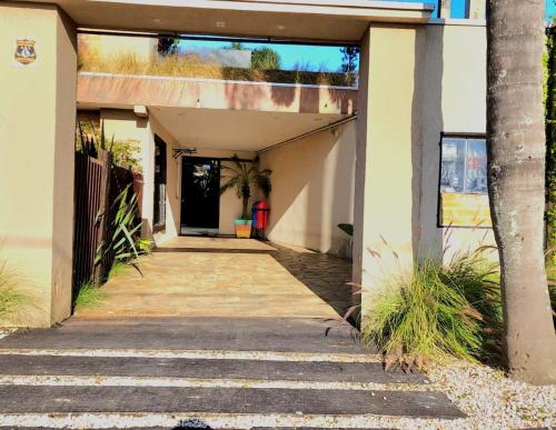 a walkway leading to a building with a door at Bangalô das Lagartixas ,casa stúdio com piscina aquecida privativa a 20 minutos do Centro de Curitiba in Colombo