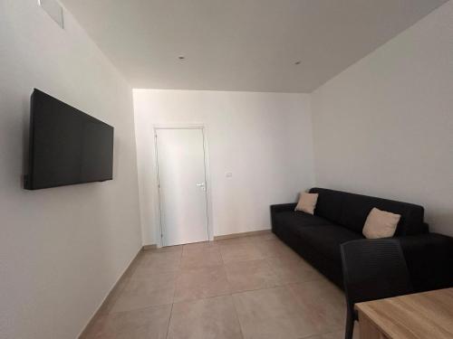 a living room with a couch and a flat screen tv at Wellness House in Bagheria