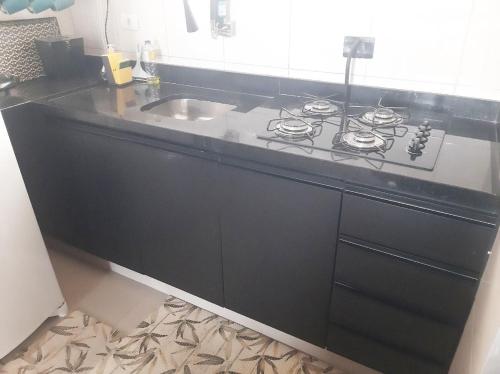 a kitchen counter with a stove and a sink at Studio à Beira-mar - Santos in Santos