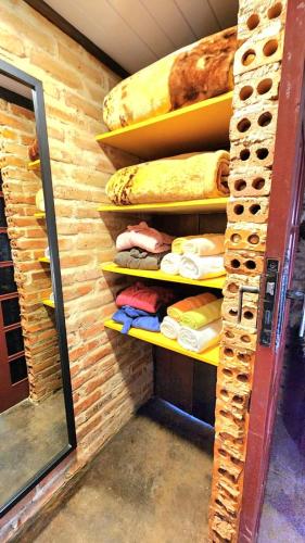 a room with shelves with some bread and rolls at Bangalô das Lagartixas ,casa stúdio com piscina aquecida privativa a 20 minutos do Centro de Curitiba in Colombo