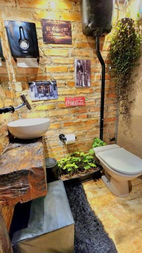 a bathroom with a toilet and a sink at Bangalô das Lagartixas ,casa stúdio com piscina aquecida privativa a 20 minutos do Centro de Curitiba in Colombo