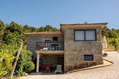 an external view of a stone house with a balcony at Casa do Amial in Castelo de Paiva