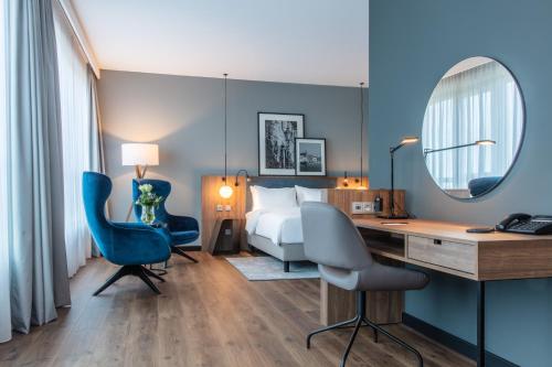 a hotel room with a bed and a desk and chairs at ScanHotels City in Rostock