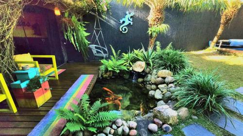 a garden with a fish pond in a yard at Bangalô das Lagartixas ,casa stúdio com piscina aquecida privativa a 20 minutos do Centro de Curitiba in Colombo