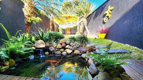 a koi pond in the yard of a house at Bangalô das Lagartixas ,casa stúdio com piscina aquecida privativa a 20 minutos do Centro de Curitiba in Colombo