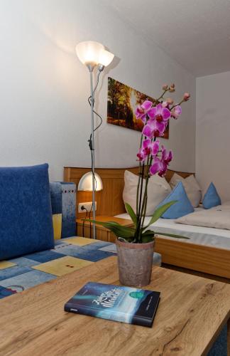 a table with a book and a vase of flowers on it at Landhotel Tannenhof in Spiegelau