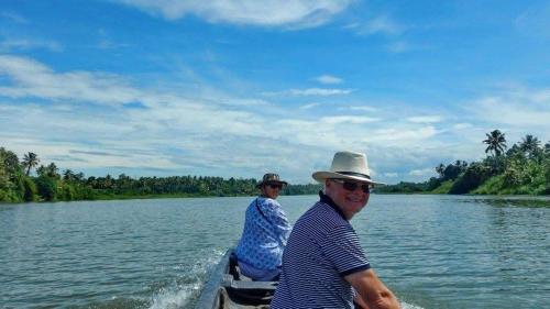 a man and woman riding in a boat on a lake at Pearl Spot in Alwaye