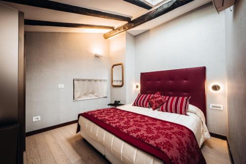 a bedroom with a large bed with a red headboard at Hotel Villa Madruzzo in Trento