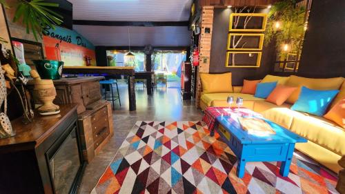 a living room with a couch and a table at Bangalô das Lagartixas ,casa stúdio com piscina aquecida privativa a 20 minutos do Centro de Curitiba in Colombo