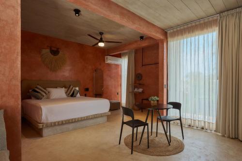a bedroom with a bed and a table and chairs at Casa Nadó in Brisas de Zicatela
