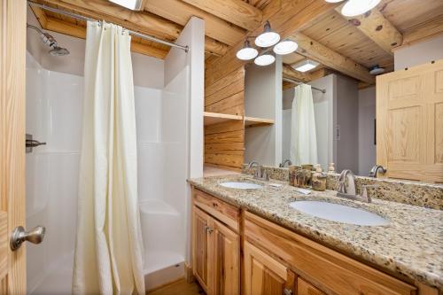 ein Badezimmer mit zwei Waschbecken und einer Dusche in der Unterkunft Wildflowers by American Patriot Getaways in Cartertown