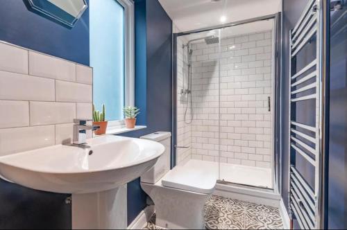 Un baño con lavabo blanco y ducha. en Barbican's Luxurious Townhouse, en Plymouth