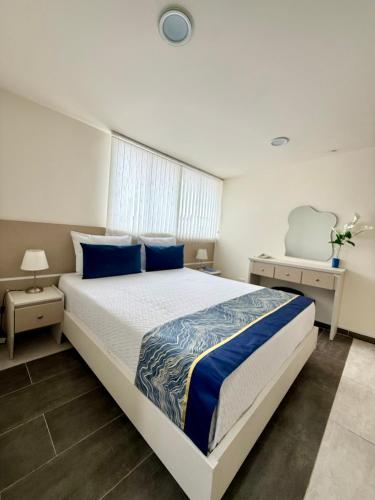 a bedroom with a large bed with blue pillows at Hotel Boutique Paralela Real. in Manizales
