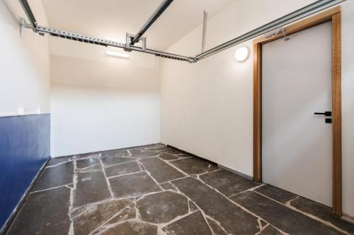 an empty room with a door and a stone floor at L Ecrin d Ailleurs in Ath