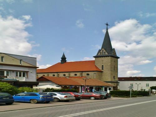 a church with a steeple with cars parked in front of it at Holiday Home in Dobczyce near Ski Lift in Dobczyce