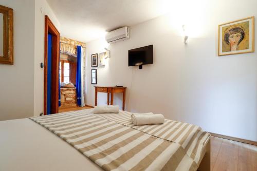 a bedroom with a bed with a striped blanket on it at George's rooms in Stari Grad