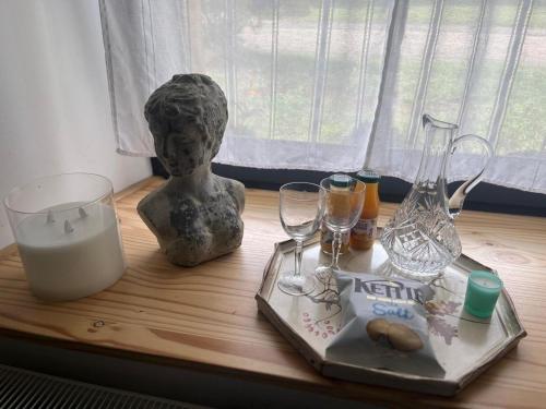 a table with a statue and wine glasses on it at Maison 1838 