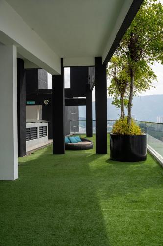 an outdoor area with green grass and a tree at Seaview Urban suites Georgetown @Penang in Jelutong