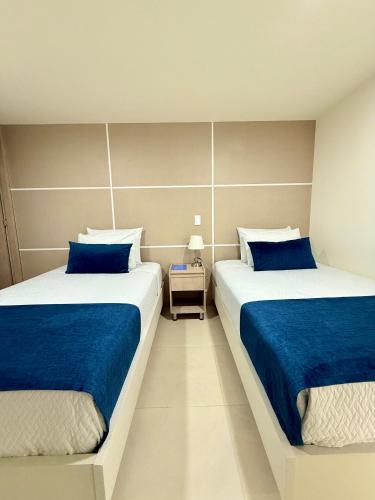 two beds sitting next to each other in a bedroom at Hotel Boutique Paralela Real. in Manizales