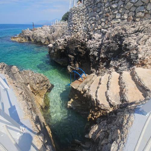 a blue bench on a cliff near the ocean at Hotel Kunjui in Utjeha