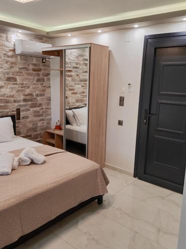 a bedroom with a bed and a mirror and a door at Rosso Verde Apartments in Kókkinon Nerón