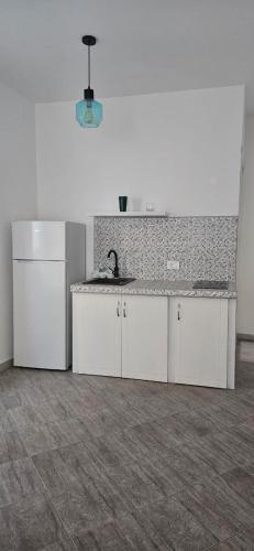a kitchen with white cabinets and a sink at Hotel Kunjui in Utjeha