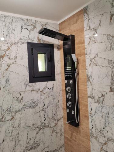 a phone hanging on a wall next to a marble wall at Rosso Verde Apartments in Kókkinon Nerón