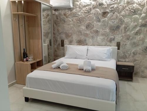 a bedroom with a large bed with towels on it at Rosso Verde Apartments in Kókkinon Nerón