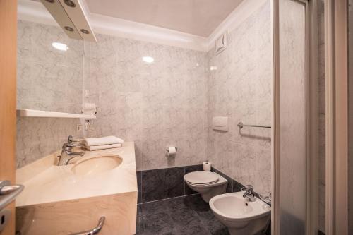 a bathroom with a sink and a toilet at Egger Apartments & Suites in Villandro