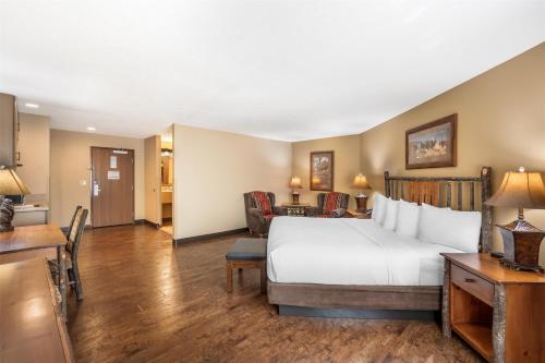 a hotel room with a large bed and a kitchen at Best Western Plus Kelly Inn & Suites in Billings