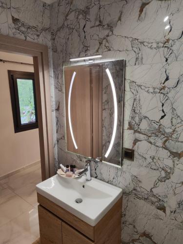 a bathroom with a sink and a mirror at Rosso Verde Apartments in Kókkinon Nerón