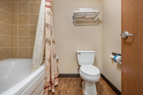 a bathroom with a toilet and a bath tub at Best Western Plus Kelly Inn & Suites in Billings