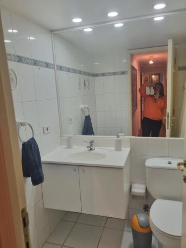 a woman taking a picture in a bathroom mirror at Reñaca Cochoa departamento frente al mar in Vina del Mar