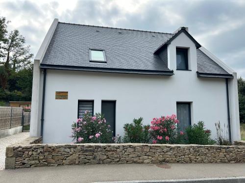 a white house with a stone wall at Maison spacieuse, centre sarzeau in Sarzeau