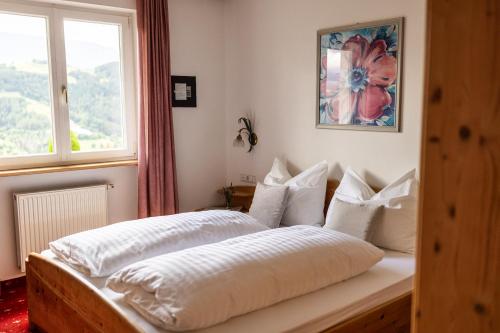 a bedroom with two beds and a window at Egger Apartments & Suites in Villandro