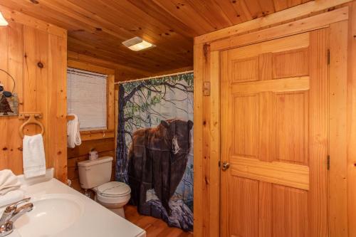 un bagno con un dipinto di mucca sulla tenda della doccia di Wonders In The Sky by American Patriot Getaways a Oldham