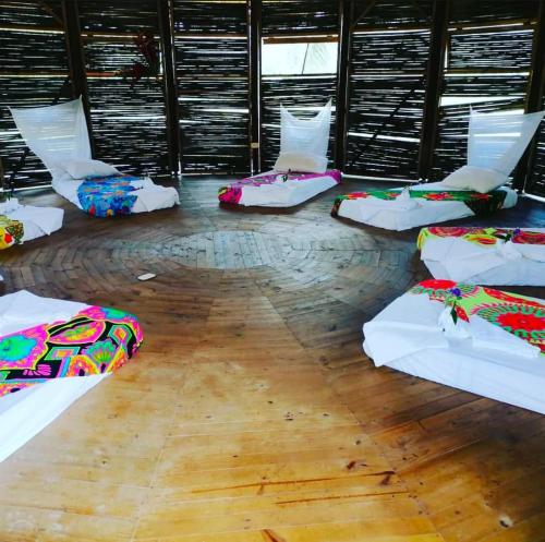 a room with several beds on a wooden floor at Kipara te Etnoaldea Indígena in Nuquí
