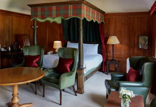 a bedroom with a bed and a table and chairs at Flitwick Manor Hotel in Flitwick