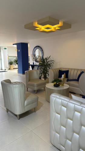 a living room with couches and chairs and a table at Hotel Boutique Paralela Real. in Manizales
