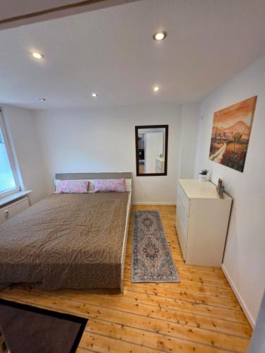 a bedroom with a bed and a wooden floor at Stilvolles City Apartment Iserlohn, möbliert und all-inclusive in Iserlohn