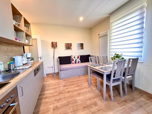 a kitchen and dining room with a table and a couch at die Senfbude - wunderschöne Apartments für 4 Personen mit Terrasse & Stellplatz in Leipzig