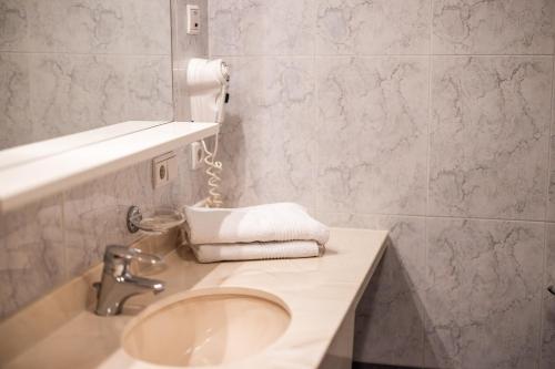 a bathroom with a sink and a towel on a counter at Egger Apartments & Suites in Villandro