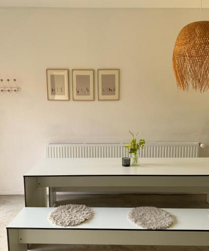 a white table in a room with two pictures on the wall at Ferienwohnung DREI Hof Himmelgrün in Saal